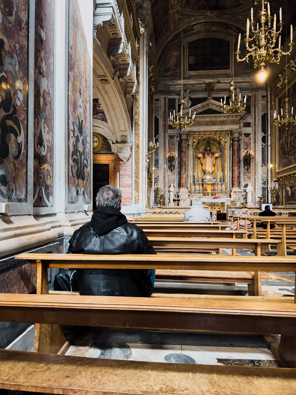 Man in a church sitting on a pew